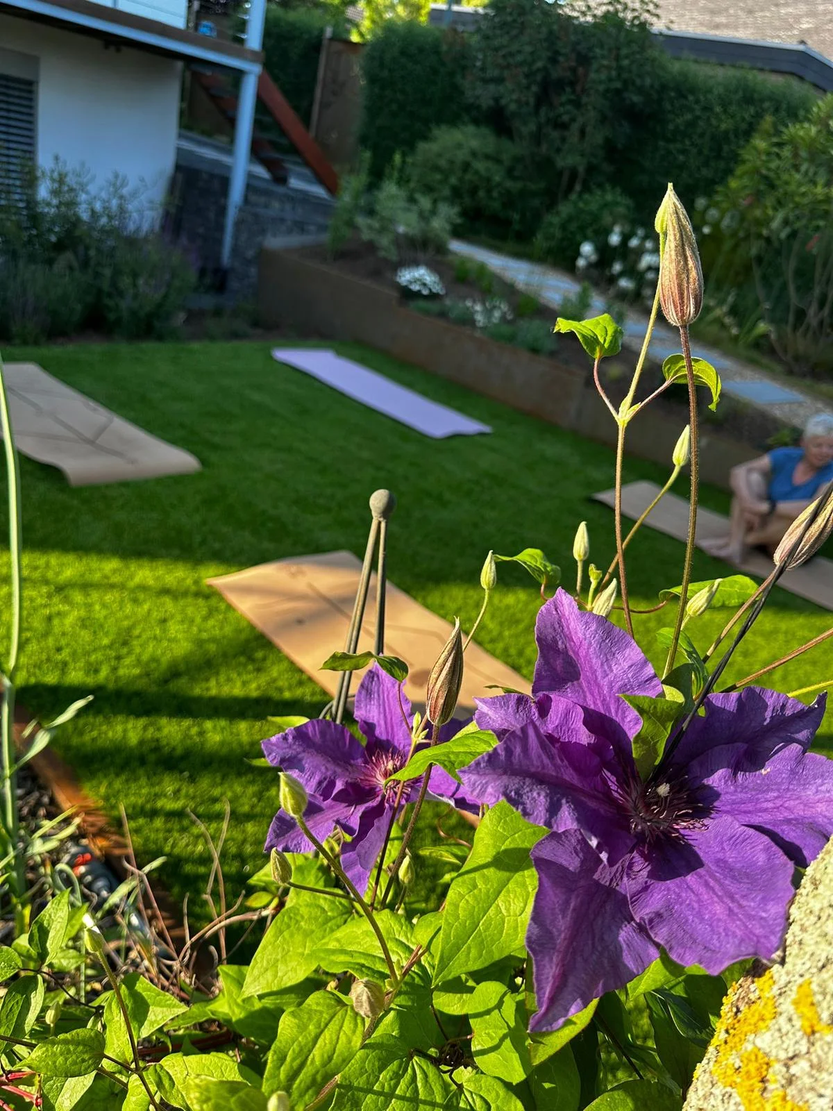 Yogamatten und Blüten im Garten