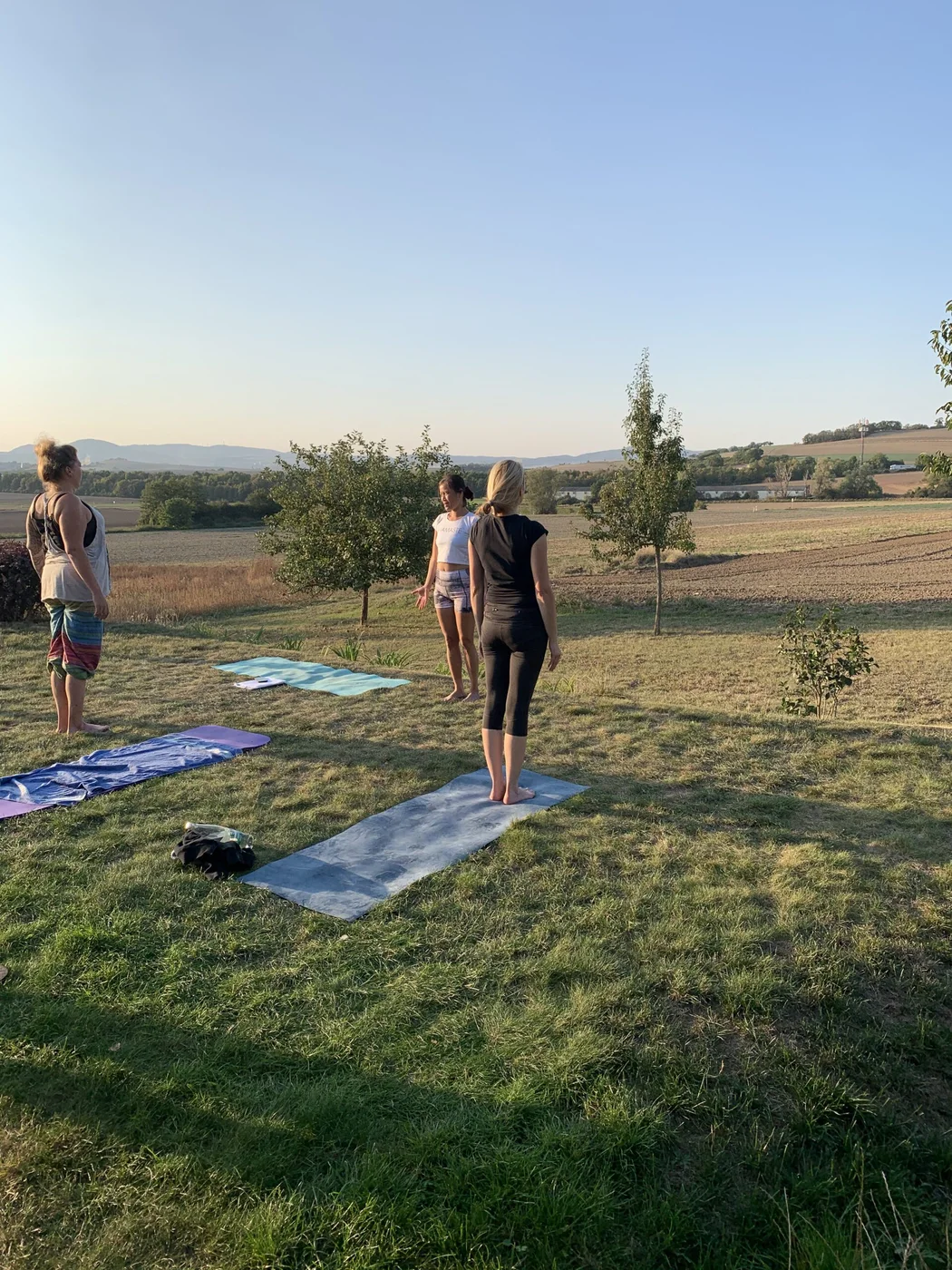 Yogagruppe auf einer Wiese mit Blick über das Maifeld